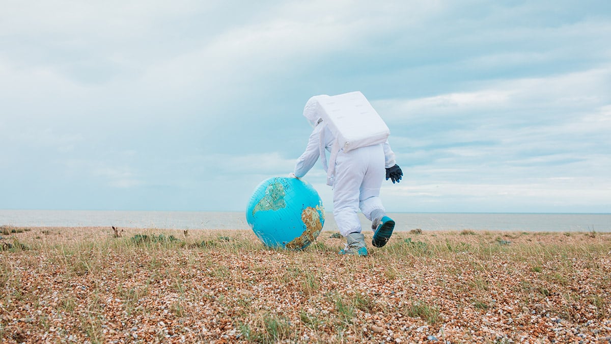 astronauta jugando con un globo terráqueo