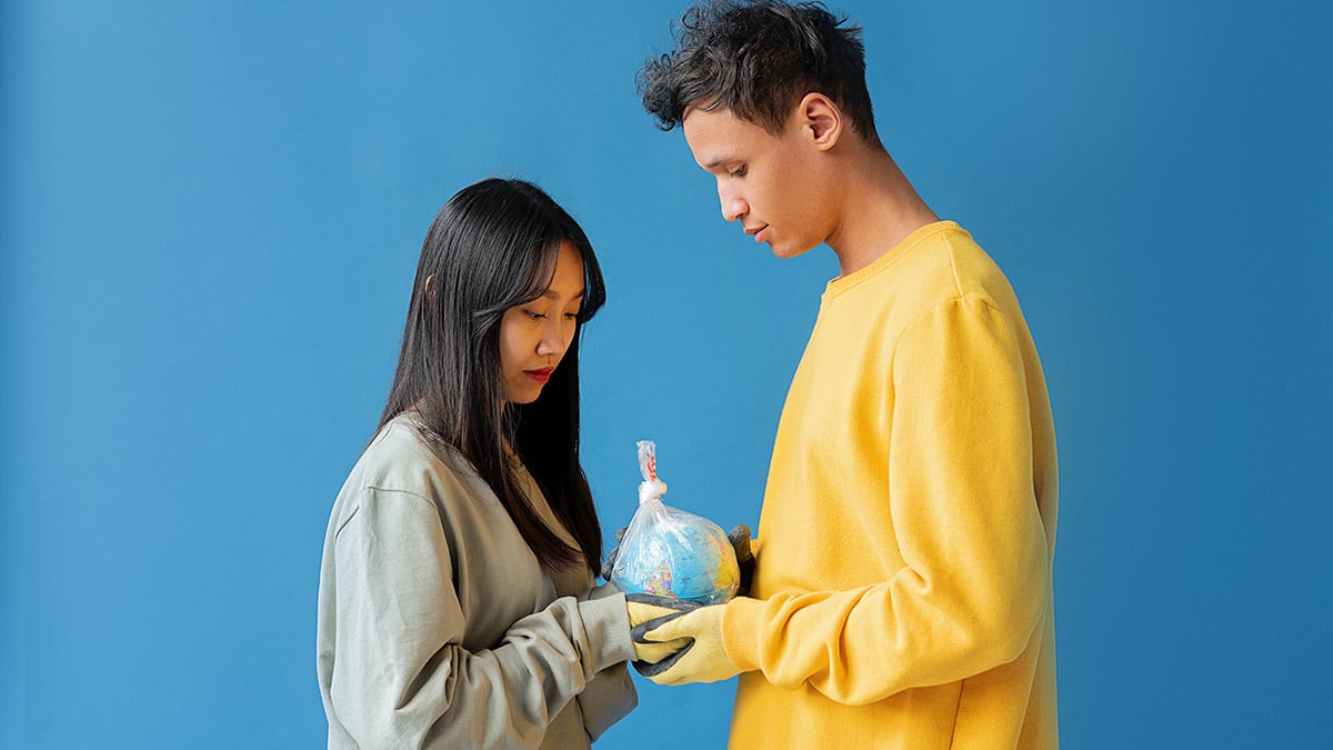 hombre y mujer sujetando globo terráqueo
