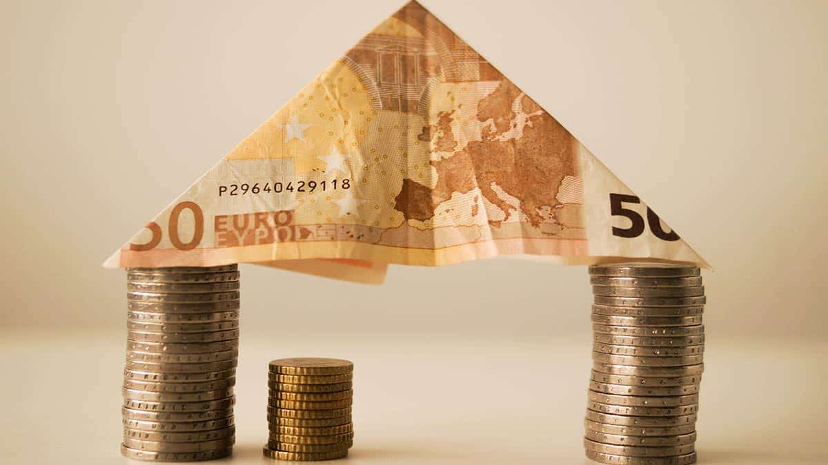 Monedas sujetando un billete